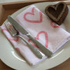 A hand block printed napkin printed with a Textile/ fabric paint in a Vine Heart design