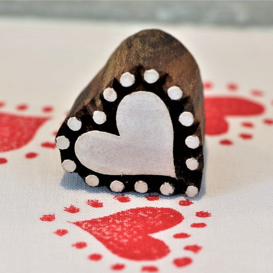 A hand carved indian wooden printing block which can be used for printing on paper or fabric in a dotty heart design